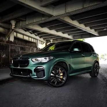 BMW, SUV, Folierung In matt-grün-metallic folierter BMW SUV steht in großer Garage